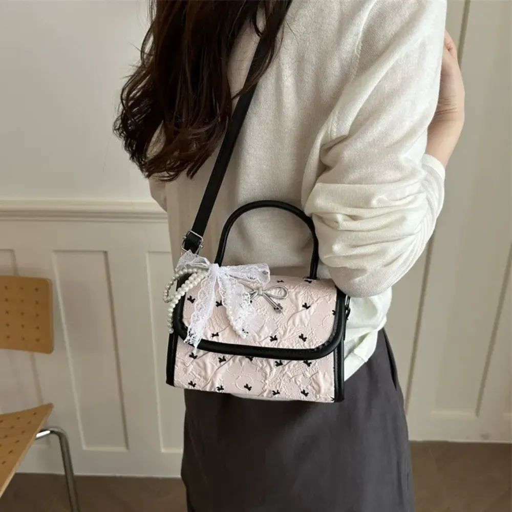 Black crossbody handbag worn by woman