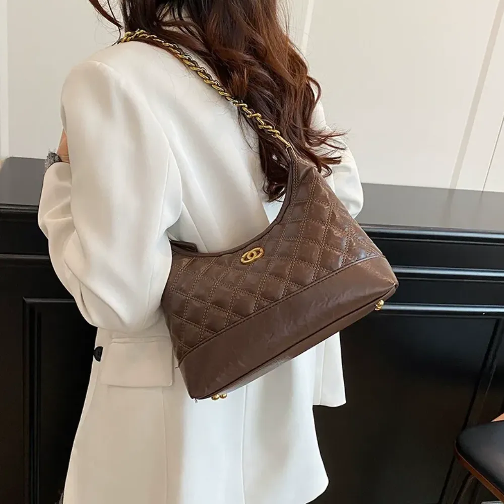 Woman wearing a brown shoulder bag with gold chain strap