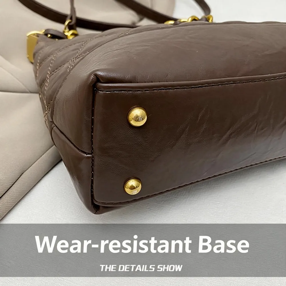 Leather handbag with protective metal feet on bottom
