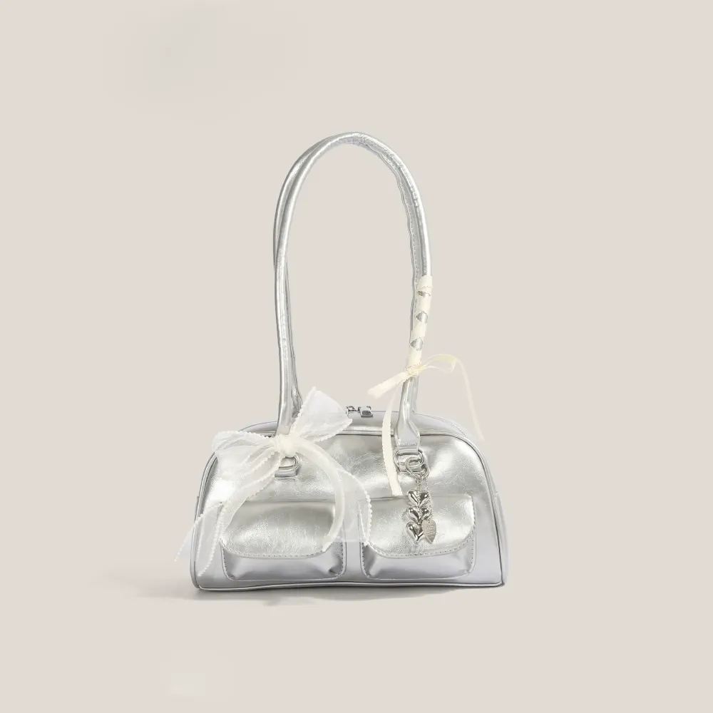 Silver bow shoulder bag with heart charm and decorative details