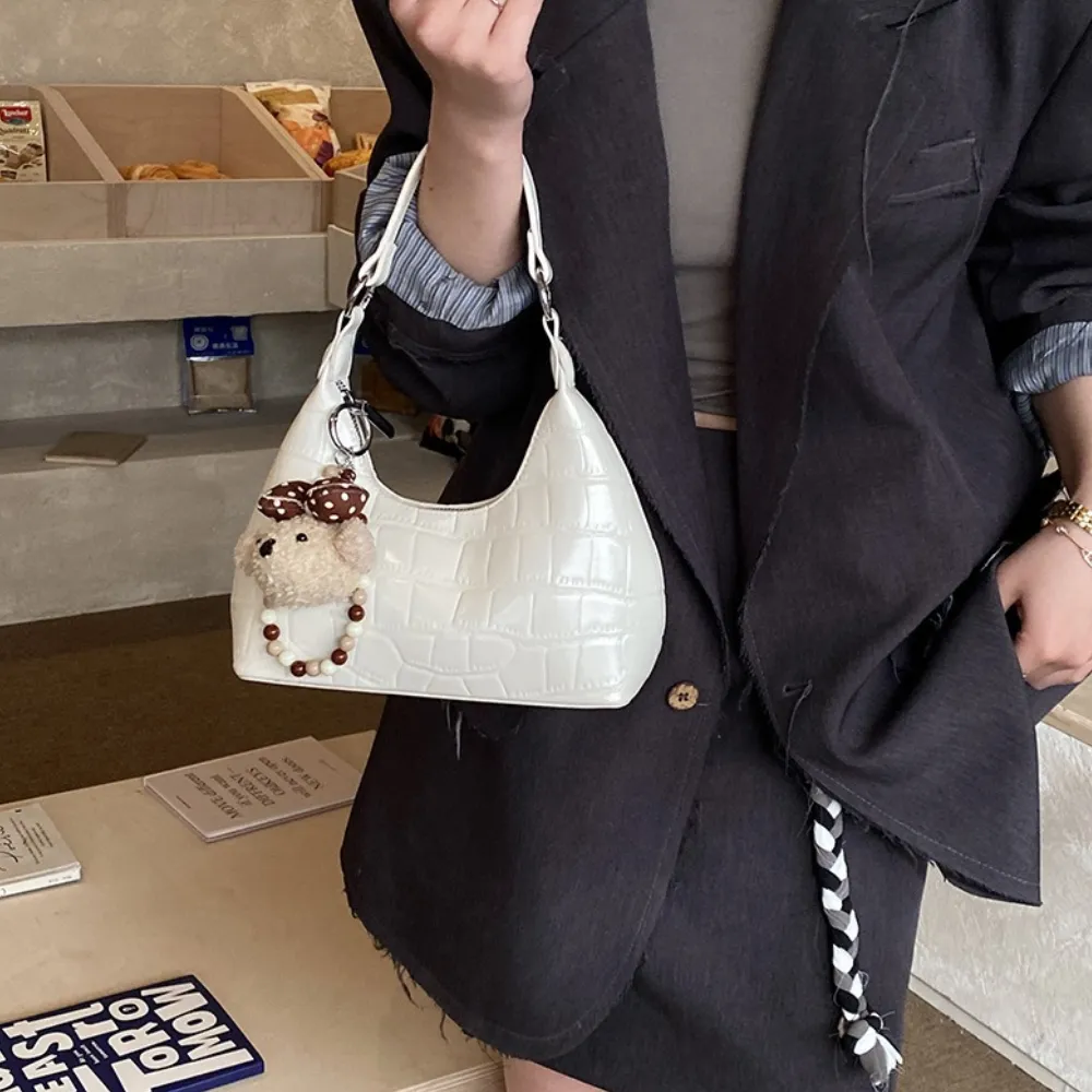 White vintage women's handbag with teddy bear charm