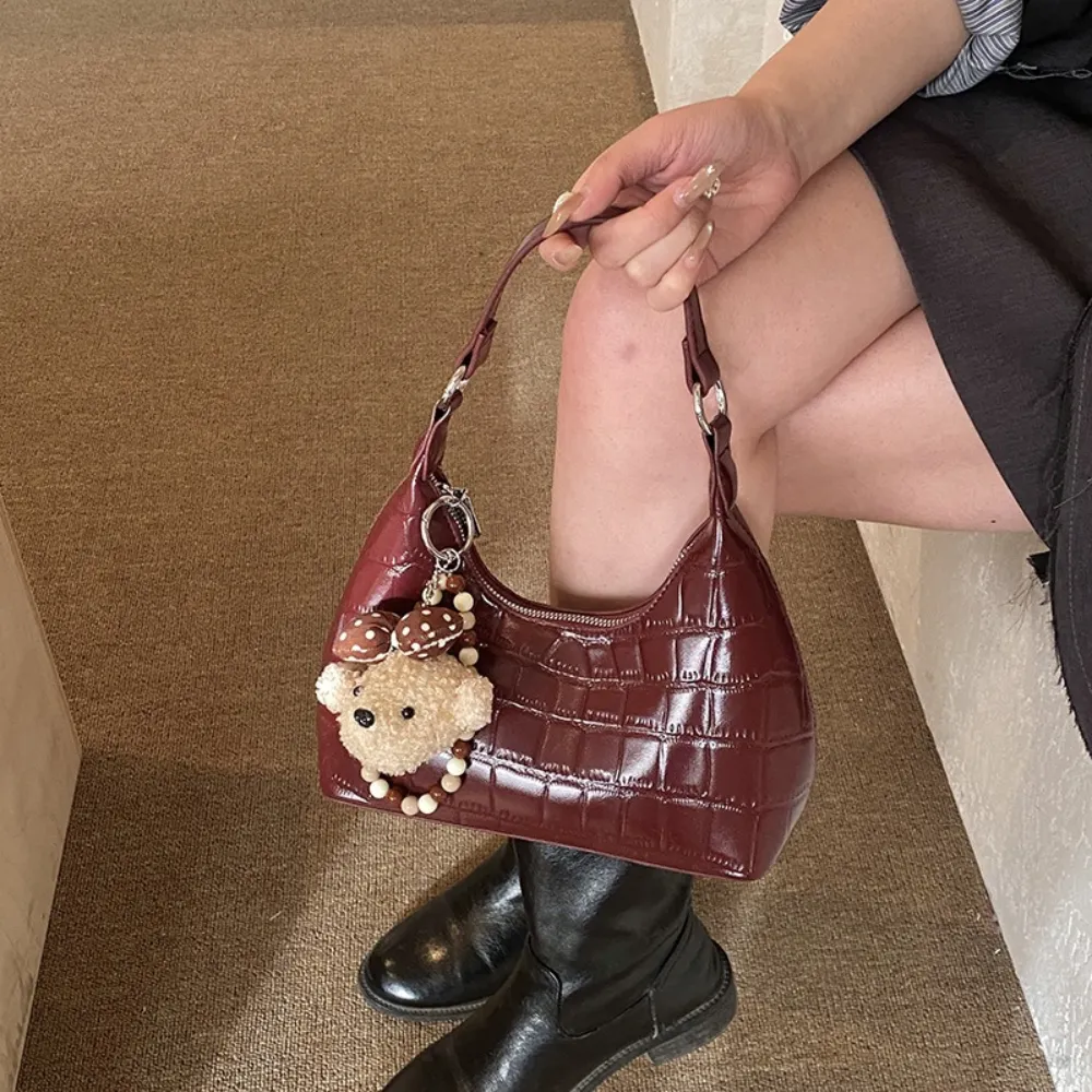 Burgundy vintage handbag with teddy bear charm